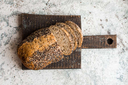 Fresh sliced bread on wooden board on the rural kitchen table. Traditional bakery concept. Rustic...