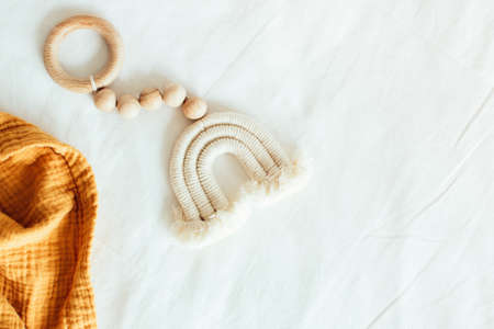 Baby wooden toy teether eco natural. Scandinavian nordic style rainbow toy with orange blanket on...