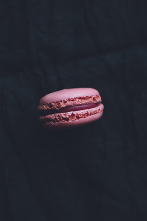 One macaroon on dark background, pink french cookies macaroonsの写真素材