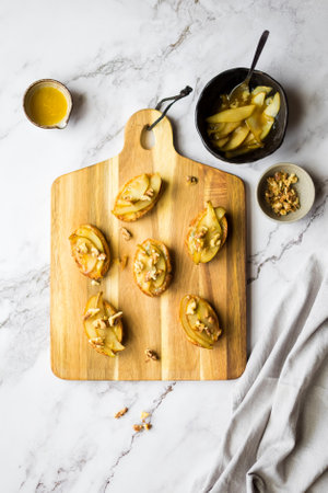 Appetizer bruschetta with pear, honey, walnut and blue cheese on marble background. Sweet toast with pear, cheese and honey. Healthy snack or breakfast. Top view. High quality photo.の写真素材