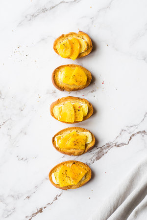 Baguette slices with cream cheese, persimmon, honey, and nuts