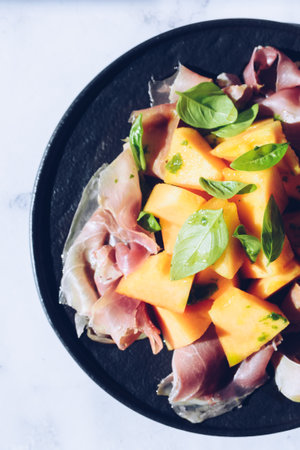 Italian style salad with prosciutto, melon and basilの写真素材