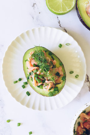 Healthy salad with avocado, smoked salmon, green onion and dill