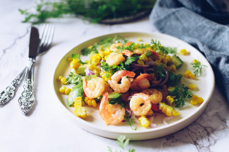 Healthy salad with fresh vegetables - corn, avocado, red onion, shrimp and coriander on a white plate.の写真素材