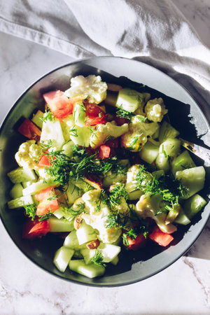 Healthy plant salad with cauliflower, tomatoes, cucumber, almond and dillの写真素材