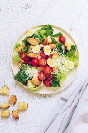Classic caesar salad with grilled chicken, lettuce, croutons and parmesan cheeseの写真素材