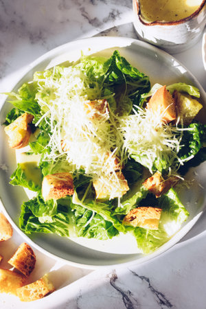 Classic caesar salad with lettuce, croutons and parmesan cheeseの写真素材
