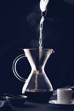 Brewing coffee with a filter dripper. Coffee dripping through a paper filter. Alternative way to make coffee.の写真素材