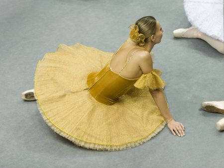 The ballerina sits on a floorの写真素材