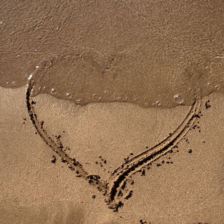 A perfect Valentine love symbol. A heart shape on the sand in a sunny day. の写真素材