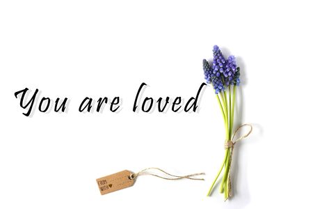 Spring blue flowers with gift tag and sign You Are Loved. Romantic, gentle, inspirational love...