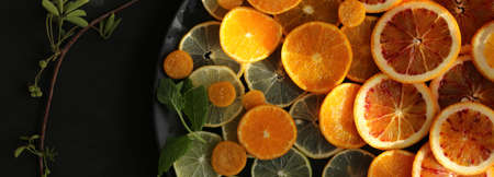 Orange fruit border. Orange citrus fruits on black background. Horizontal frame