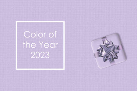 Digital Lavender Color of the Year 2023, New Year gift with bow on lavender background. In the trend...
