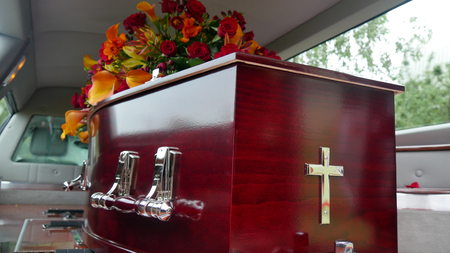 closeup shot of a colorful casket in a hearse or chapel before funeral or burial at cemeteryの写真素材