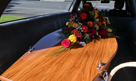 closeup shot of a funeral casket in a hearse or chapel or burial at cemeteryの写真素材