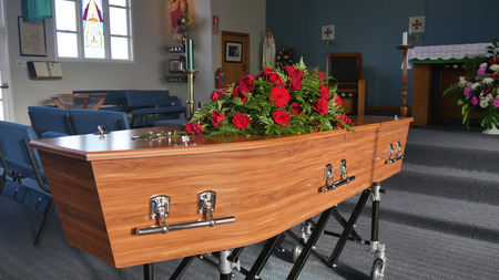 closeup shot of a funeral casket in a hearse or chapel or burial at cemetery