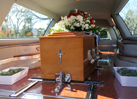 closeup shot of a funeral casket in a hearse or chapel or burial at cemeteryの写真素材
