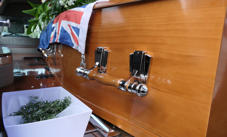 closeup shot of a funeral casket in a hearse or chapel or burial at cemetery