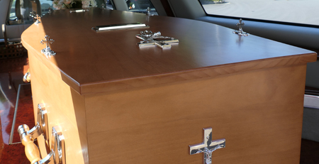closeup shot of a funeral casket in a hearse or chapel or burial at cemetery
