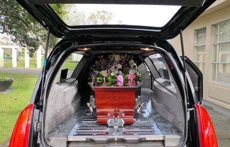 closeup shot of a funeral casket in a hearse or chapel or burial at cemeteryの写真素材