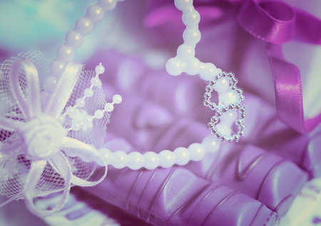 wedding rings with beads and ribbons on a pink backgroundの写真素材