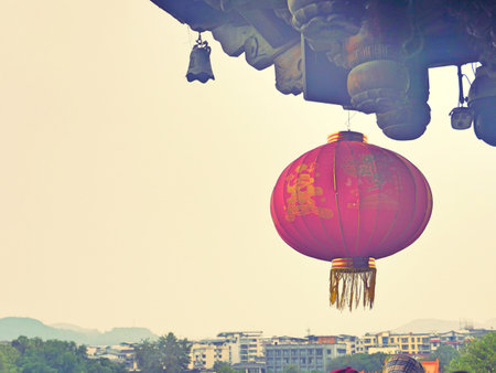 Traditional Chinese Red lantern hanging from the ceiling with old city as backgroundの写真素材