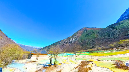 HuanglongÂ valley is made up of colorful lakes snow capped peaks green forest and glaciers