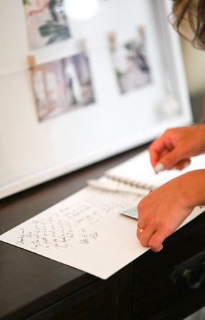 Close up of a woman's hand writing on a guest bookの写真素材
