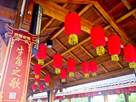 oriental red lanterns hanging on roofs and building for festive celebrationsの写真素材