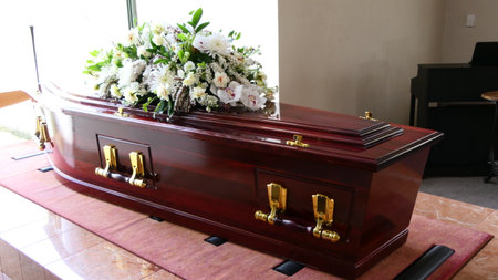 shot of a funeral casket or coffin placed on a catafalque platform ready to be lowered in a chapel or churchの写真素材