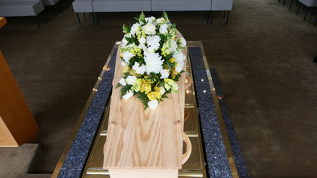 shot of a funeral casket or coffin placed on a catafalque platform ready to be lowered in a chapel or churchの写真素材