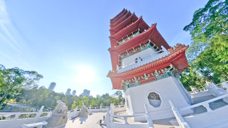 Traditional Chinese pagodas with red roofs and white railings stand under a bright blue sky.の写真素材