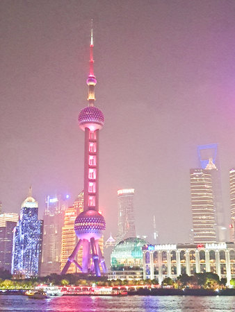 Colorful China Shanghai skyline glows at night, with the commercial towers and skyscrapers, boats...