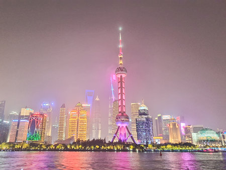 Colorful China Shanghai skyline glows at night, with the commercial towers and skyscrapers, boats...