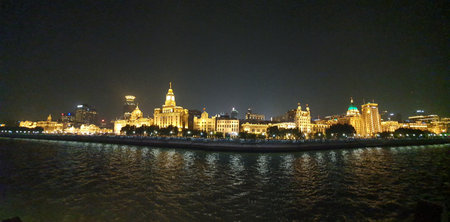 Night view of Suzhou, featuring luxury yachts docked at the waterfront and vibrant lighting along...