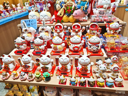 A colorful shop displays various lucky cat figurines, symbolizing fortune and happiness, arranged neatly on shelves and tablesの写真素材