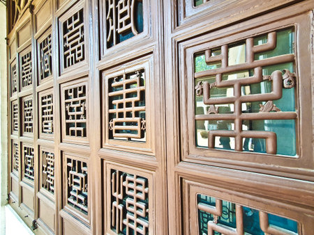 Intricate wooden windows and doors showcase traditional Chinese lattice designs, highlighting cultural heritage and skilled craftsmanship in historical architectureの写真素材