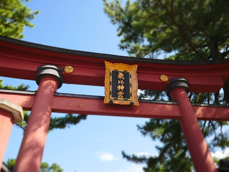 A low-angle view captures the emblems mounted on the great red Torii gateの写真素材