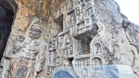 Extensive Longmen cliff grottoes displaying hundreds of carved Buddhist niches and statues across...