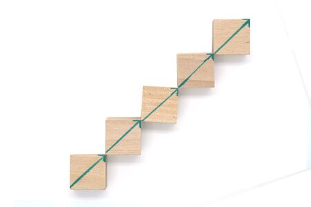 Wooden blocks with upwards arrow on white background