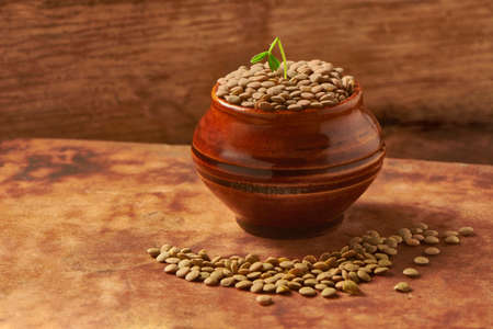 lentils with container on a wooden background in the foregroundの写真素材