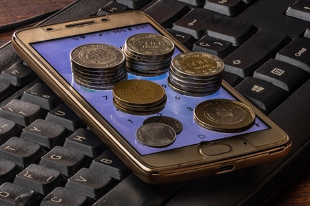 Coins on the keyboard of a smartphone. Business concept.Colombian moneyの写真素材