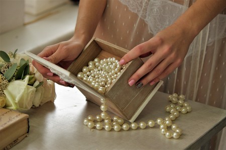 Female hands open a box with beadsの写真素材