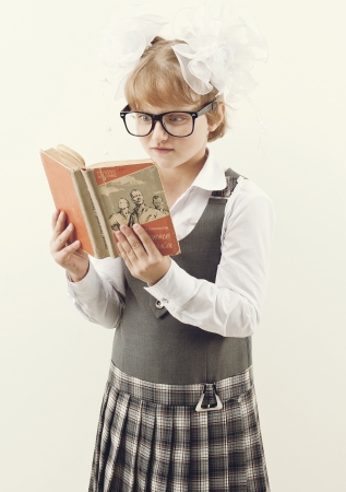 Schoolgirl with glasses reading a bookの写真素材