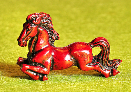 wooden figure of a horse on a green backgroundの写真素材