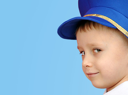 boy's head in a cap on a blue backgroundの写真素材