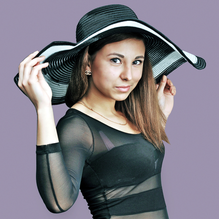 Caucasian woman holding a hat in bodyの写真素材