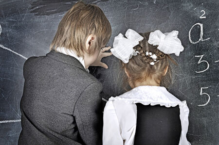 boy and girl solve problems on blackboardの写真素材