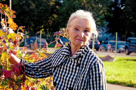 elderly woman with Parkinson's disease for a walk in the autumnの写真素材