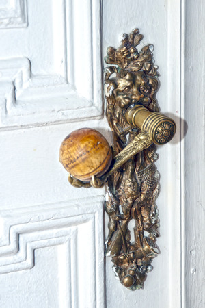 old metal door-handle on a wooden doorの写真素材